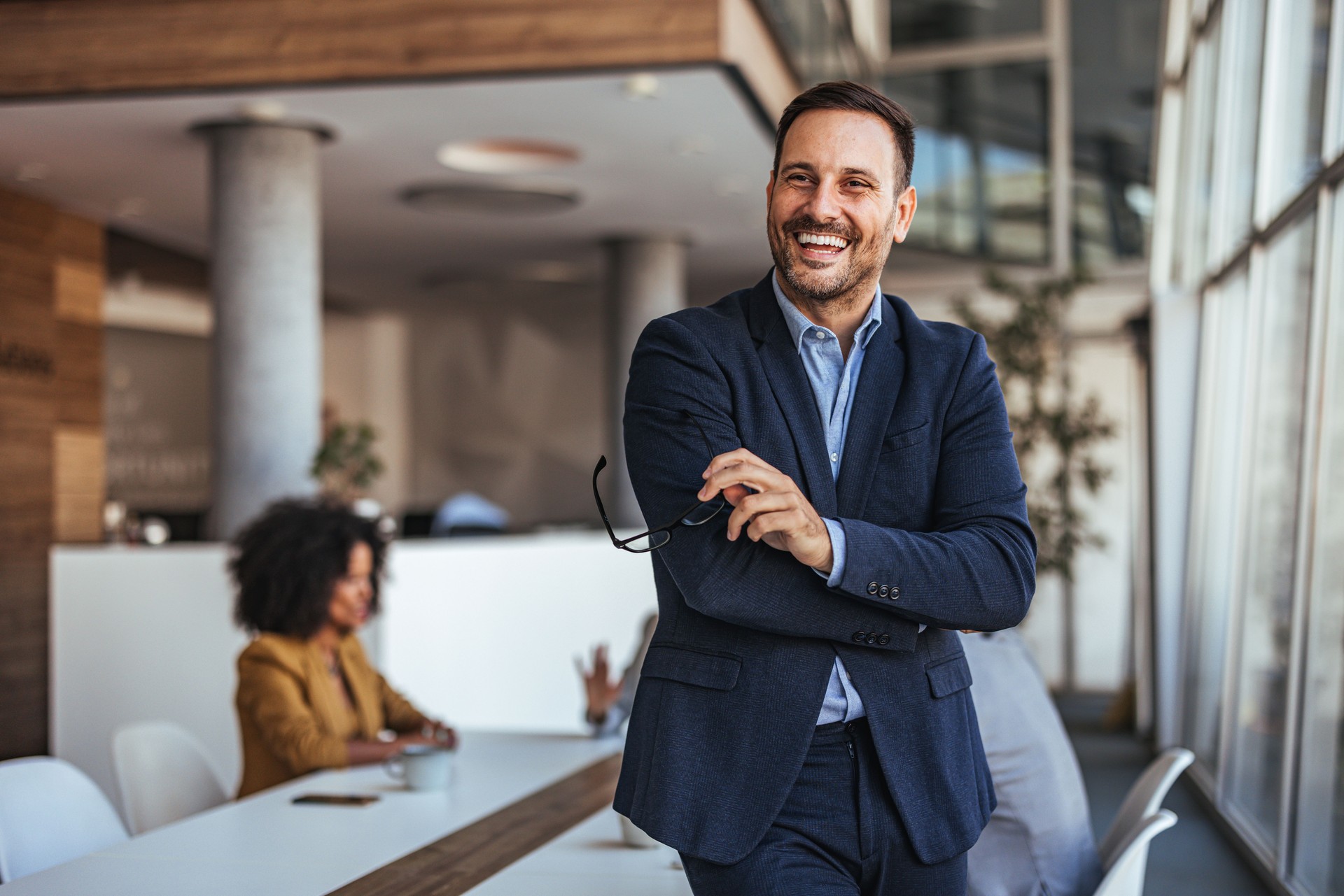 Confident Businessman Smiling in Modern Office Environment